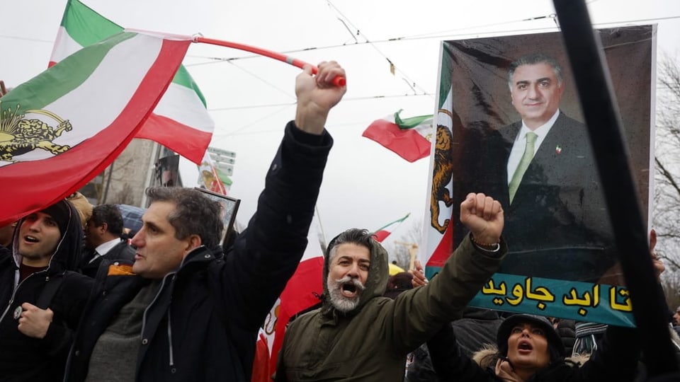 Demonstrierende Menschen mit iranischen Flaggen.