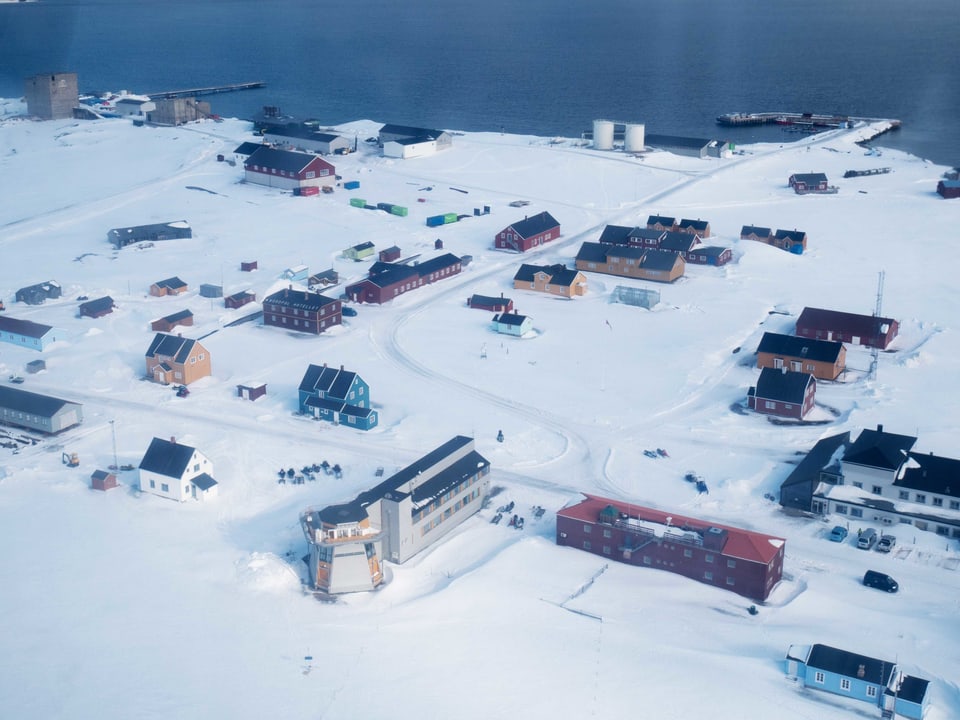 Häuser auf einer mit Schnee bedeckten Landschaft in der Arktis.