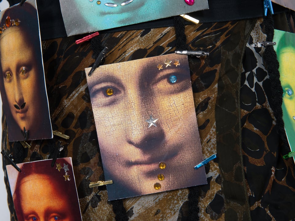 Postkarten mit Frauenporträt. Die Augen sind mit farbigen Steinchen besetzt. 