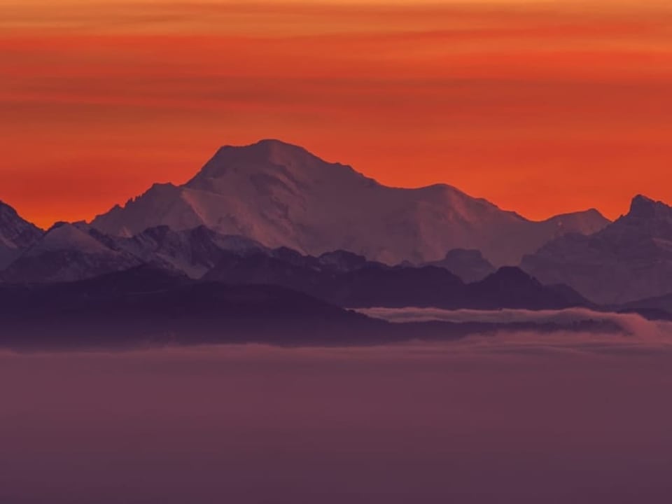 Roter Himmel mit Schleierwolken, Blick zu den Schneebergen über dem Nebelmeer unten