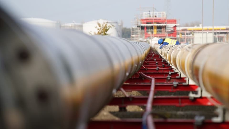 Arbeiter bauen in Deutschland Gas-Pipelines für das geplante LNG-Flüssiggas-Schwimmterminal zusammen