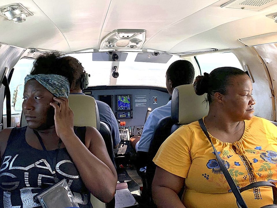 Zwei Frauen, die dem Wirbelsturm «Dorian» entkommen sind, sitzen in einem Flugzeug.
