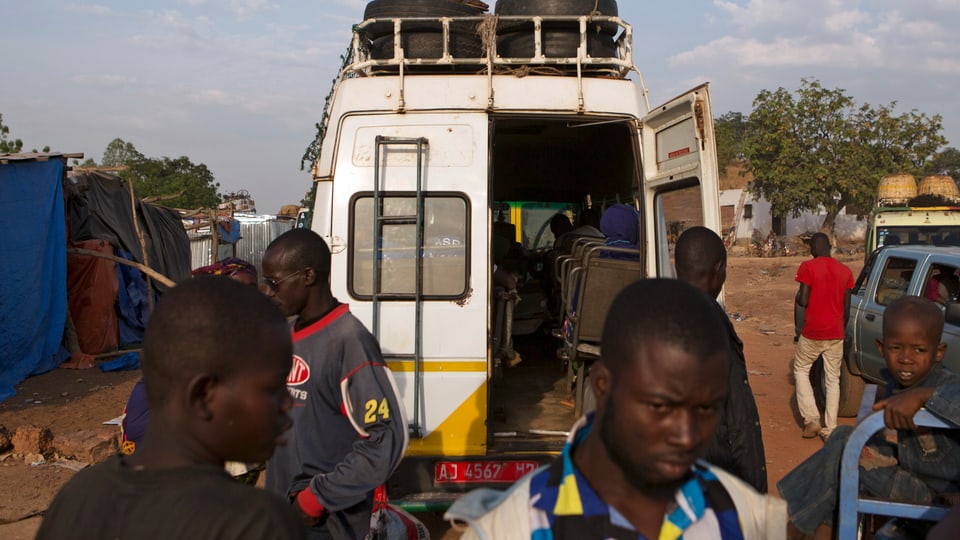 Reisende beladen einen Kleinbus für die Fahrt nach Bamako