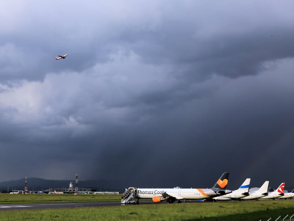 Flugzeuge parkiert, dunkle Gewitterwolken.
