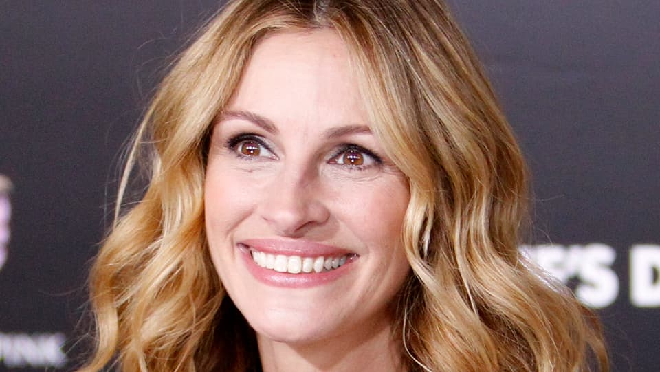 Julia Roberts in einer Nahaufnahme. Sie lacht und hat blonde Locken.