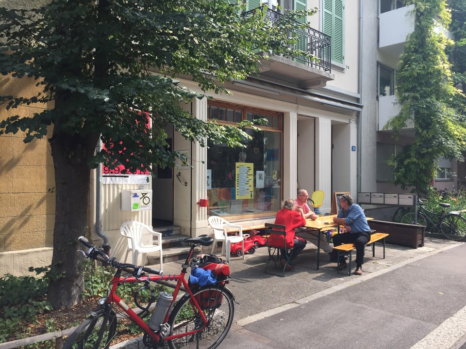 Leute sitzen vor einem Lokal an der Bärenfelserstrasse