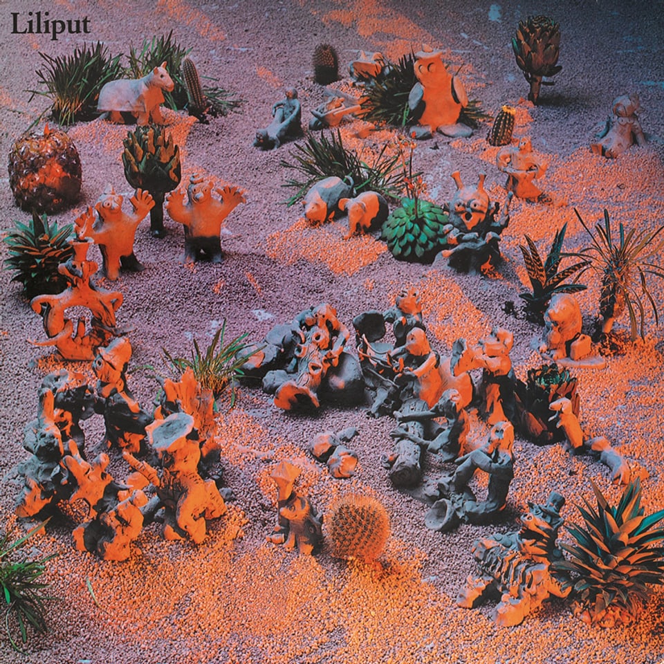 Albumcover: Foto mit mehreren Lehmfigürchen in einer Sand-Landschaft