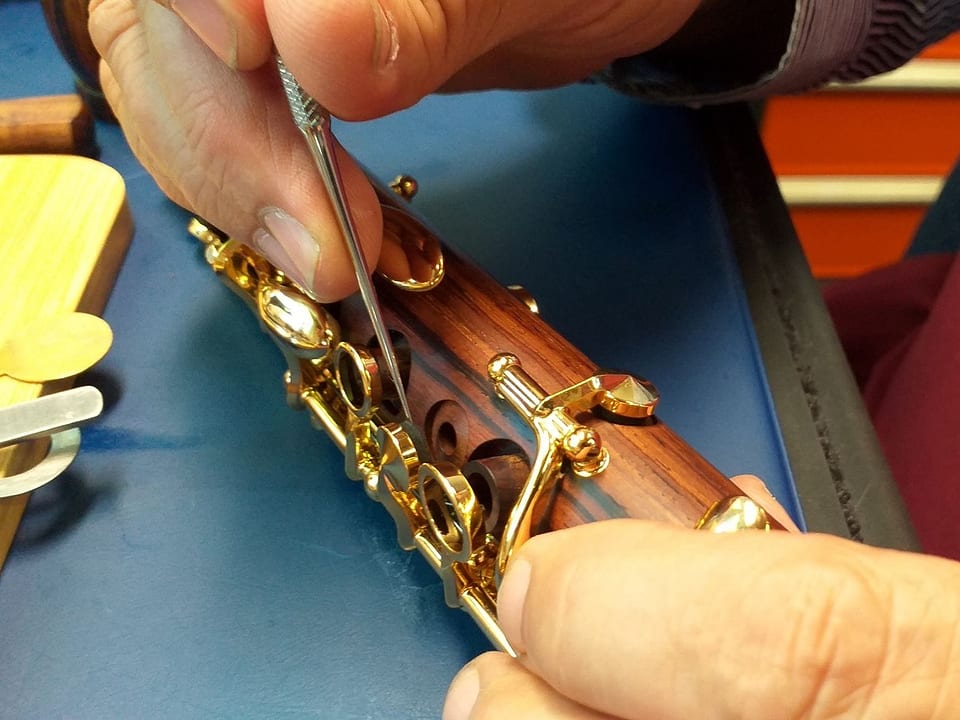 Ein Mann repariert eine Klarinette.