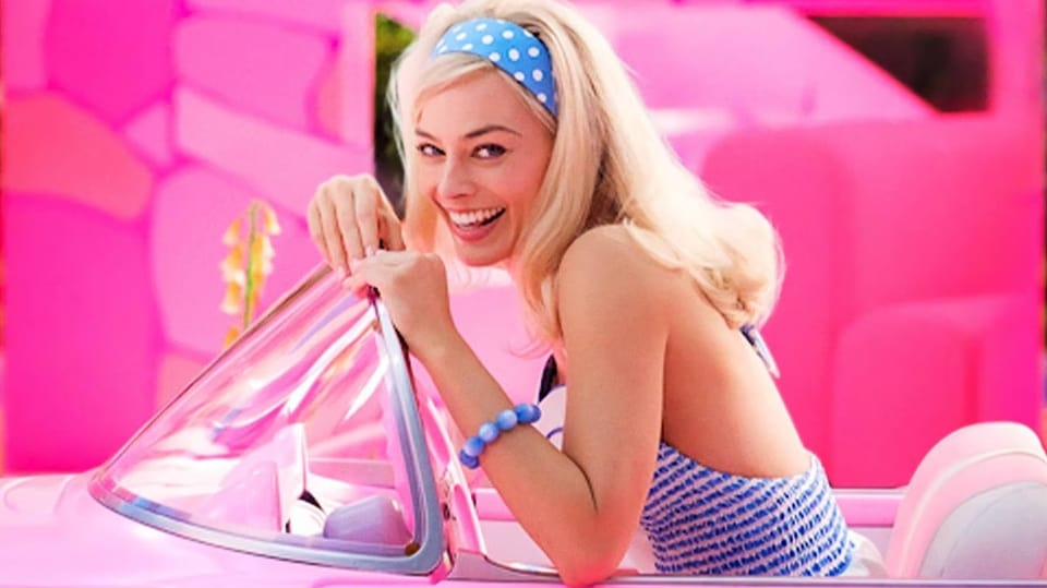 Eine blondierte, lächelnde Frau in einem Wagen.