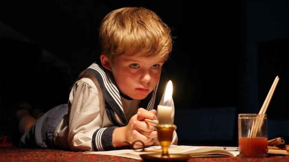 Ein kleiner Junge vor einer Kerze