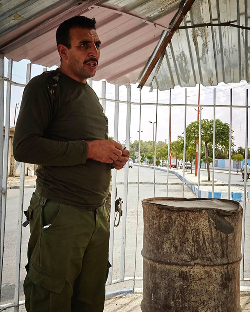 Ein kurdischer Soldat steht neben einer Tonne