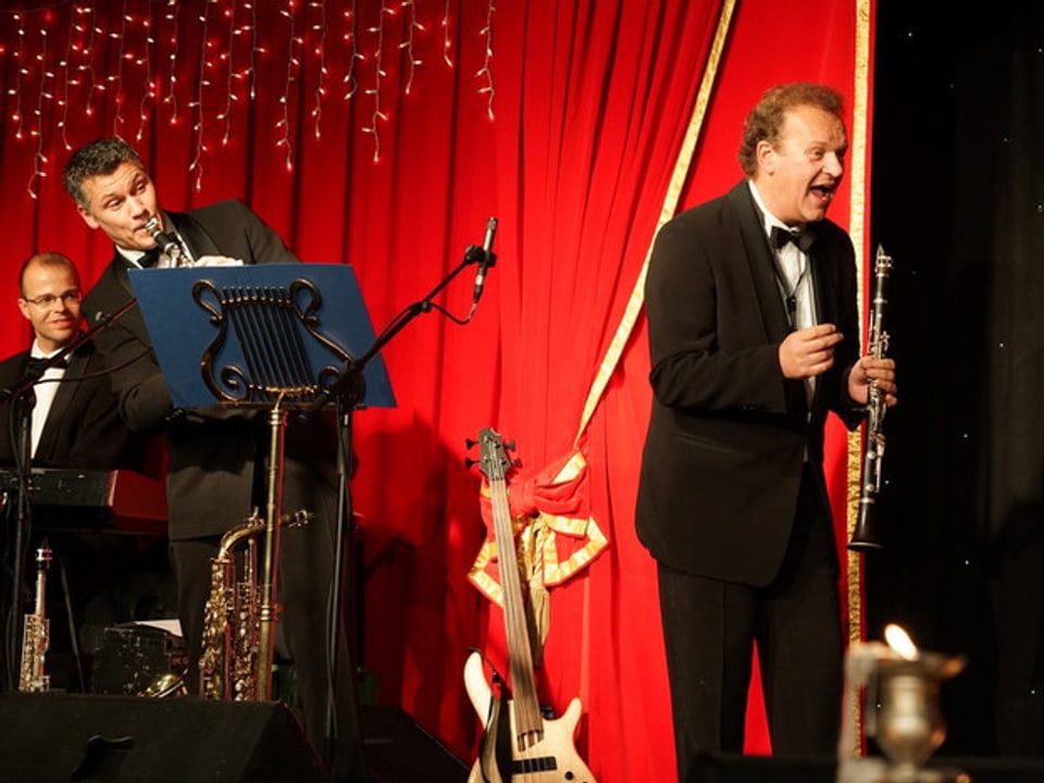 Klarinettenspieler und Mann mit Saxophon im Hintergrund. 