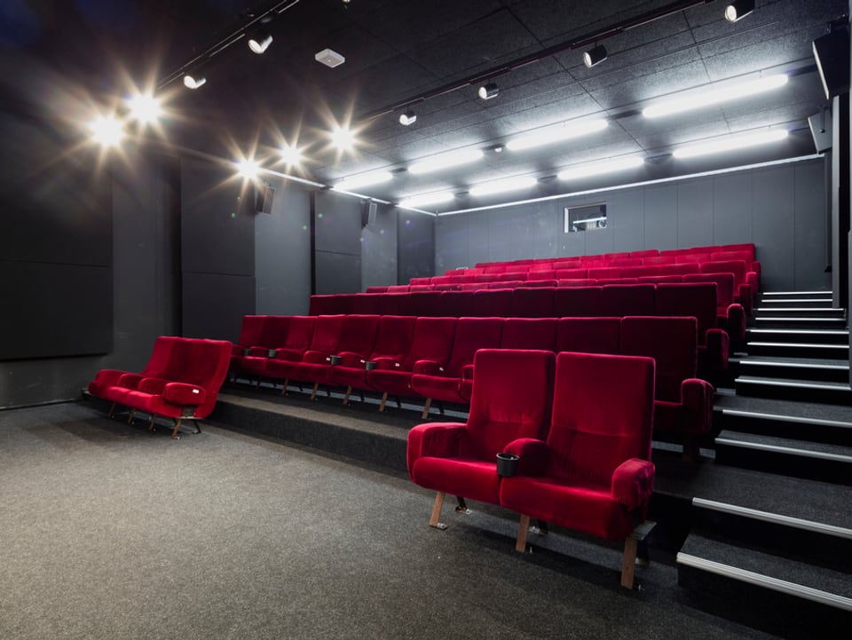 Ein Kinosaal mit roten Sesseln.