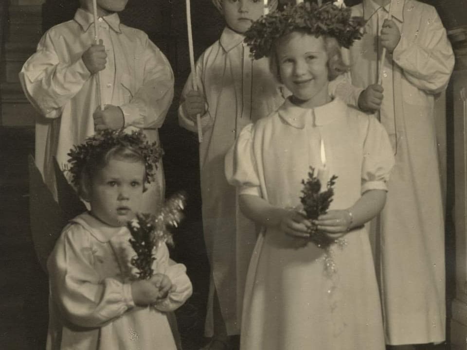 Ein schwarz-weiss Bild von Prinzessin Anne-Marie und Margrethe. Sie sind damals noch kleine Kinder, tragen beide ein weisses Kleid und halten eine Kerze in der Hand.
