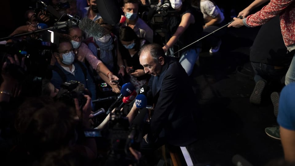 Zemmour ist umringt von Journalistinnen und Journalisten mit Mikrofonen