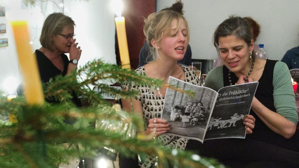 Eine Familie singt zusammen Weihnachtslieder am Heiligen Abend.