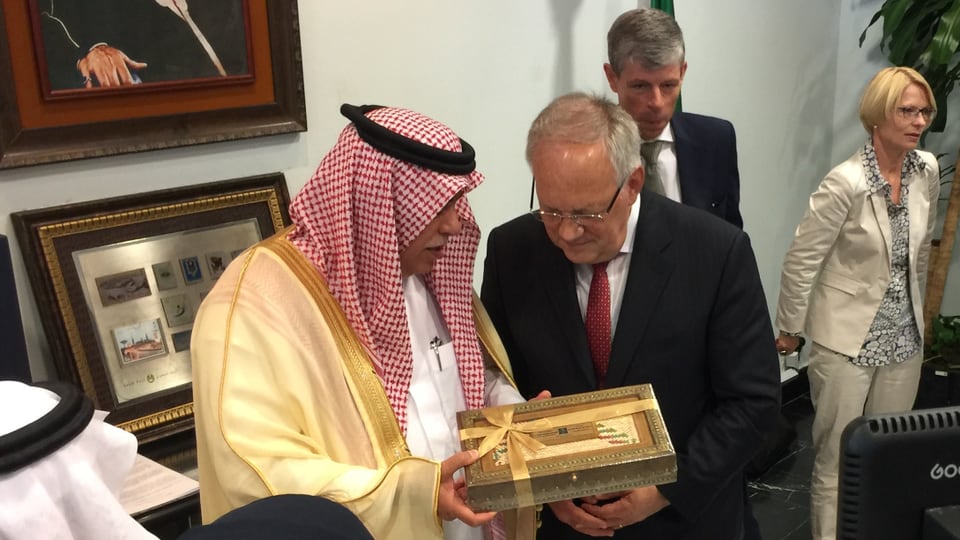 Der saudische Minister Majed Al-Qasabi überreicht Schneider-Ammann eine Schachtel Datteln.
