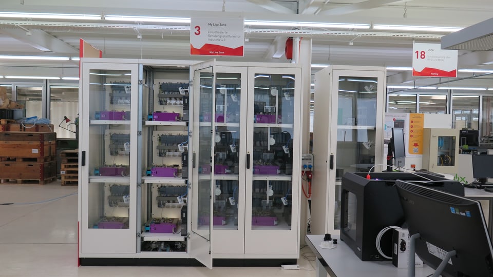 Glasschrank mit elektronischen Arbeitsplätzen in der Swiss Smart Factory