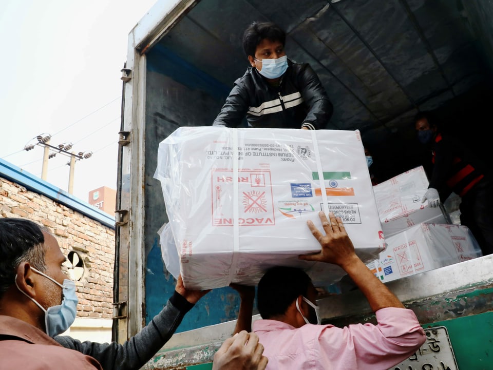 Arbeiter entladen in Dhaka einen Kleintransporter mit COVID-19-Impfstoffen