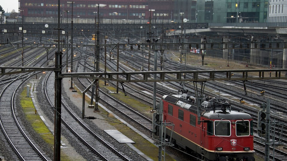 Einfahrt in den Basler Bahnhof, rechts eine rote Lokomotive der SBB