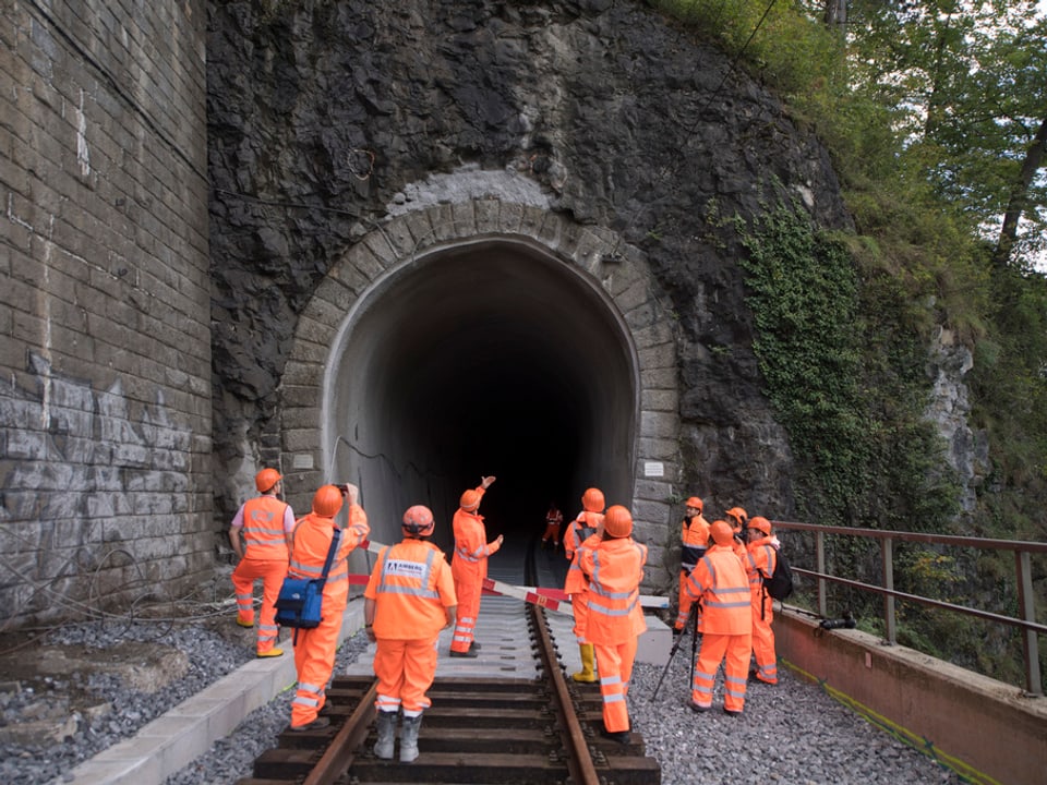 Bauarbeiter vor einem Tunneleingang. 