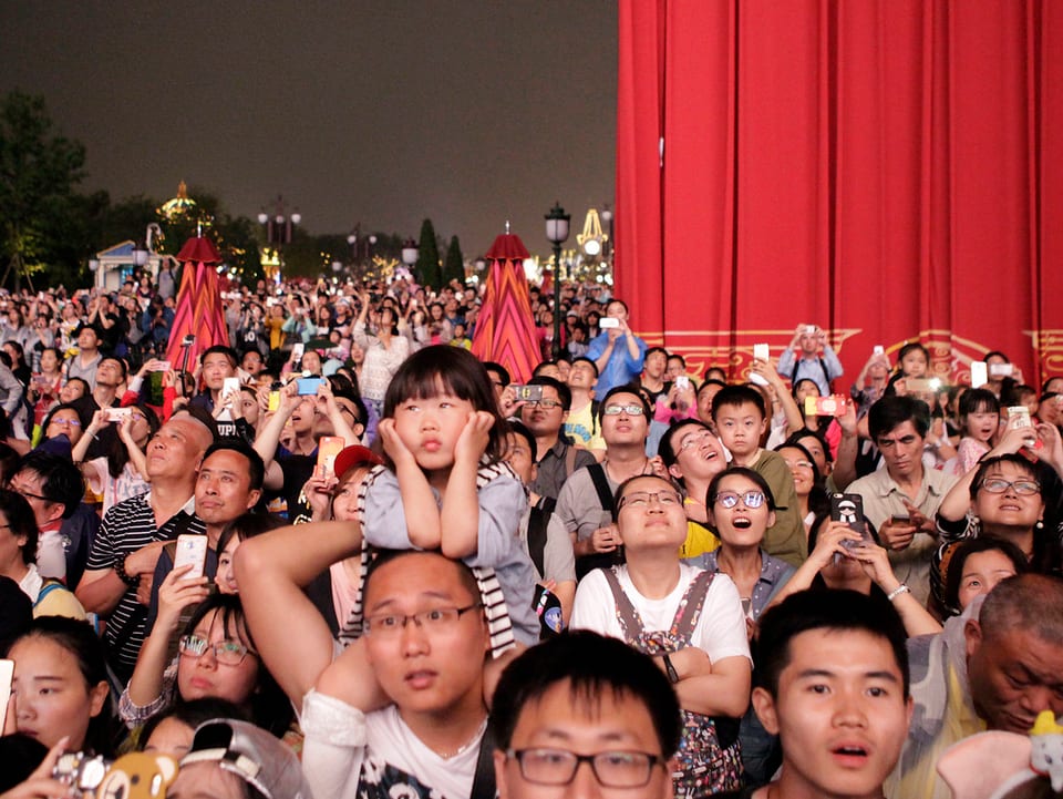 Besucher sehen sich das Feuerwerk im Disneyland Shanghai an.