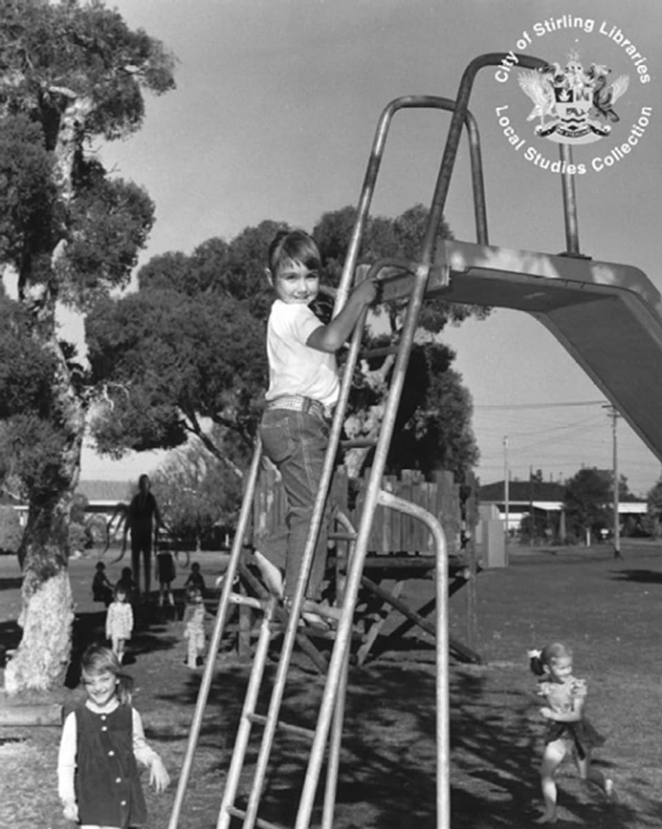 Kinder spielen auf einem Spielplatz. Im Hintergrund die Umrisse eines grossen dünnen Mannes.