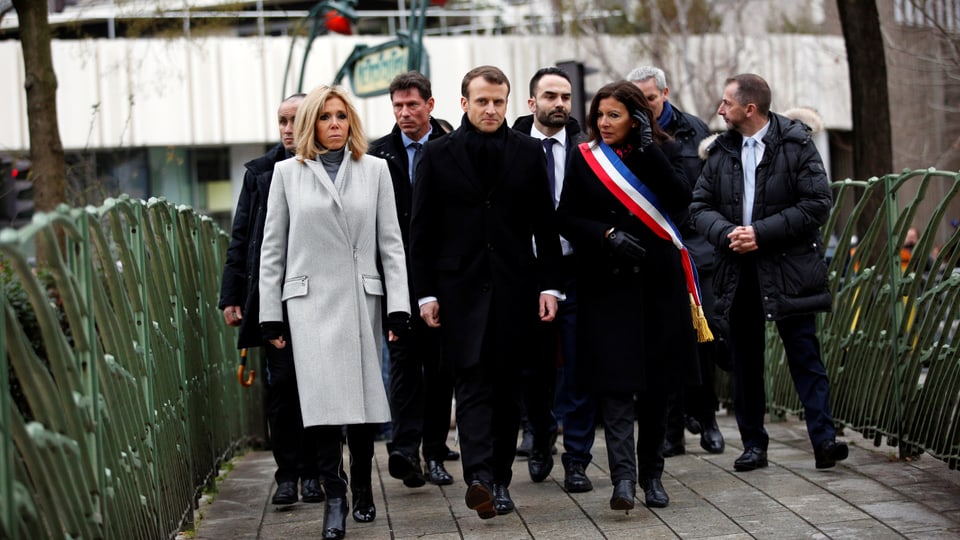 Macron und weitere Personen zu Fuss unterwegs.