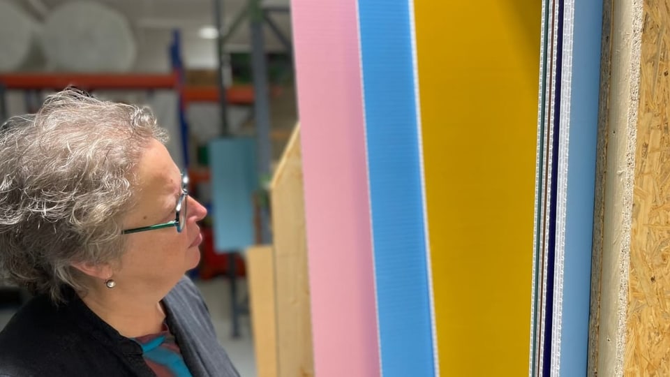 Eine Frau begutachtet farbige Holzplatten