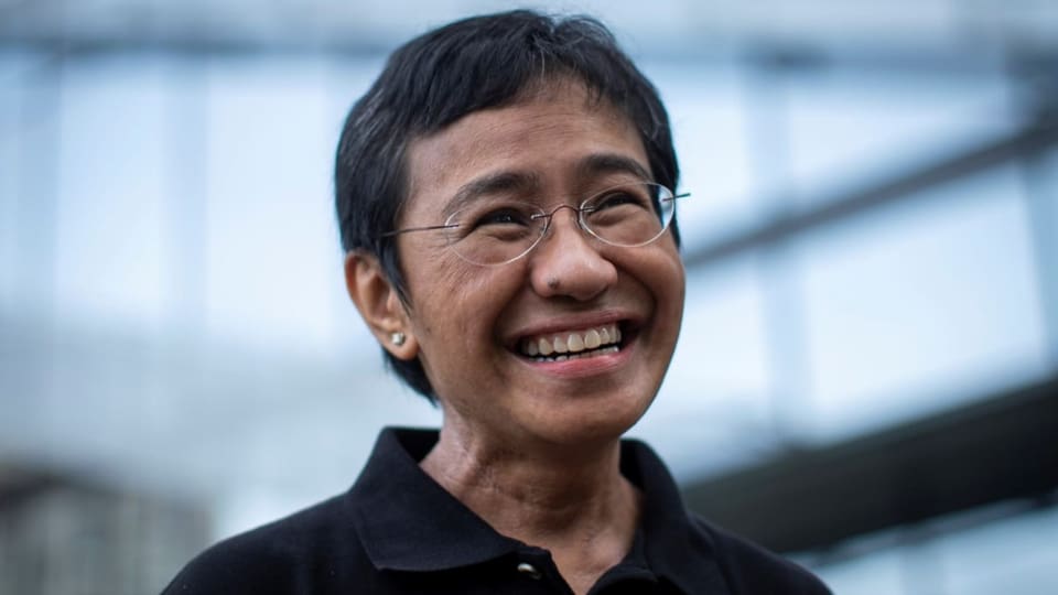 Porträt von Maria Ressa, die an der Kamera vorbei lächelt