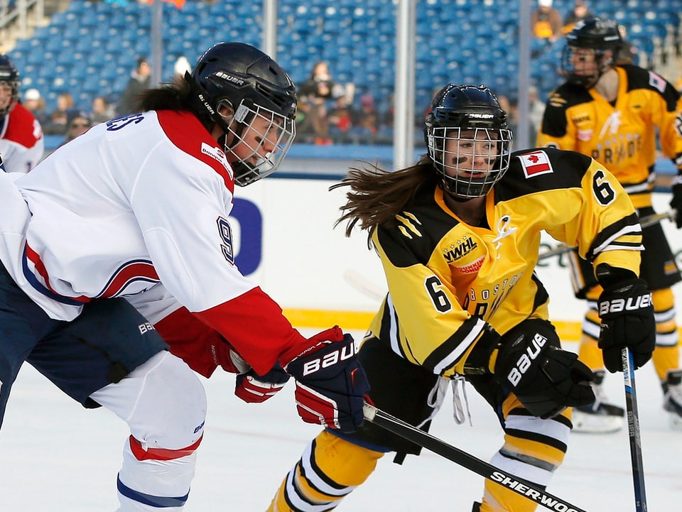 Zwei Eishockeyanerinnen kämpfen um den Puck.