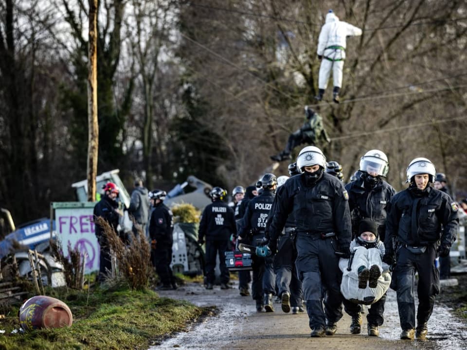 Eine Aktivistin wird von Polizistin wegtransportiert.