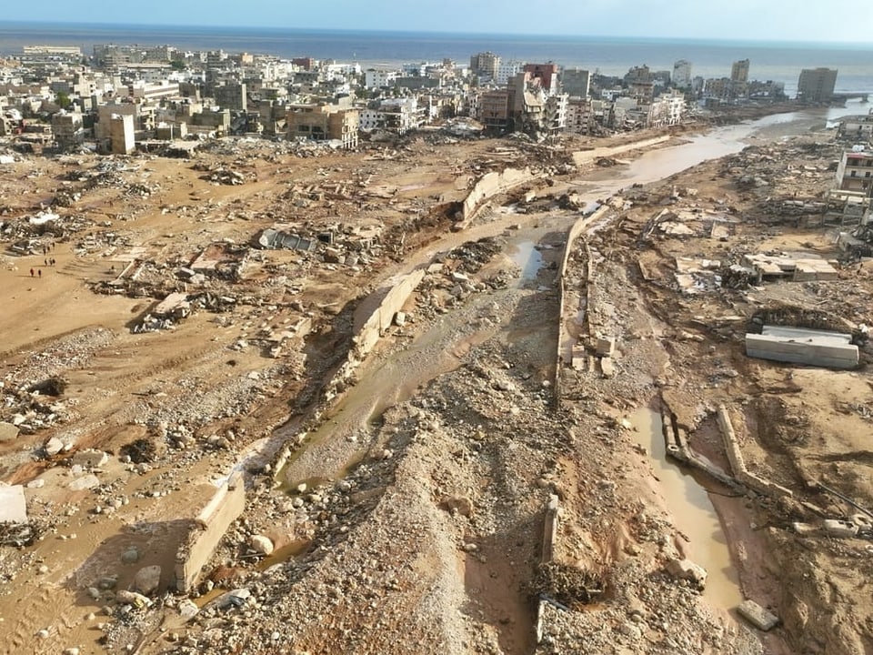 Eine Drohnenaufnahm zeigt die Verwüstung der Überschwemmung von oben. Eine grosse Schlammspur zieht sich vom Meer bis in die äusseren Zonen der Stadt Derna.