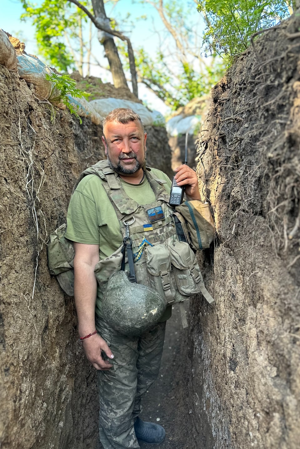 Mann mit Militärausrüstung im Schützengraben.