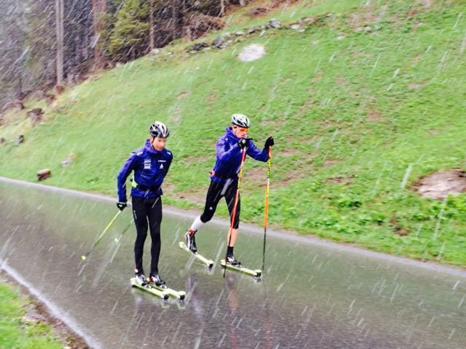 Zwei Rollskiläufer im Schneeregen.