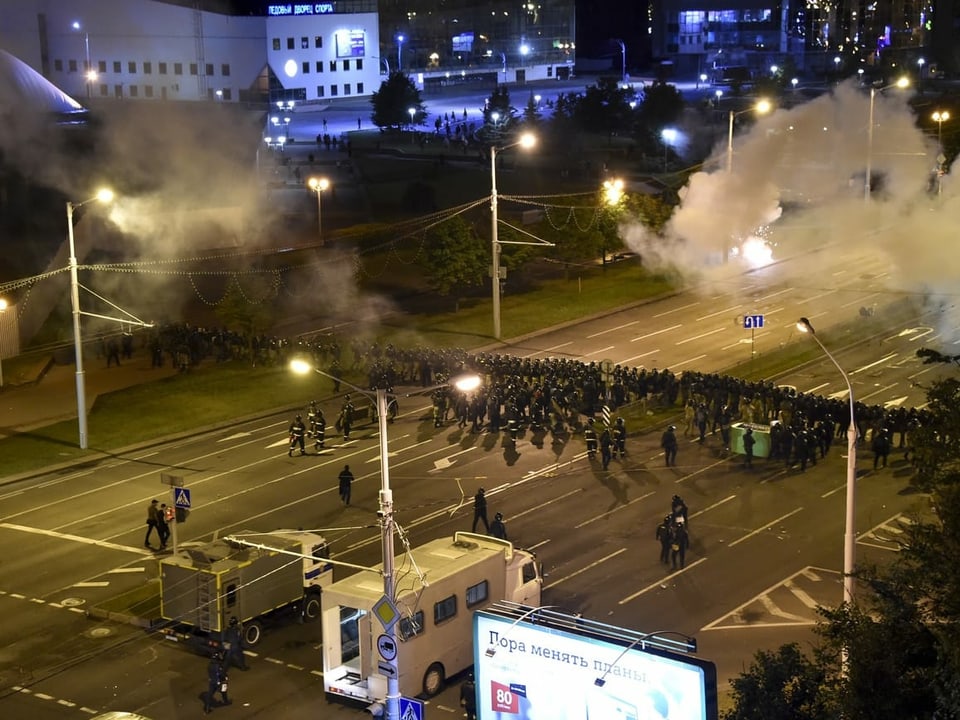 Zig Polizisten formen auf der Strasse eine Blockade, um die Demonstranten aufzuhalten.