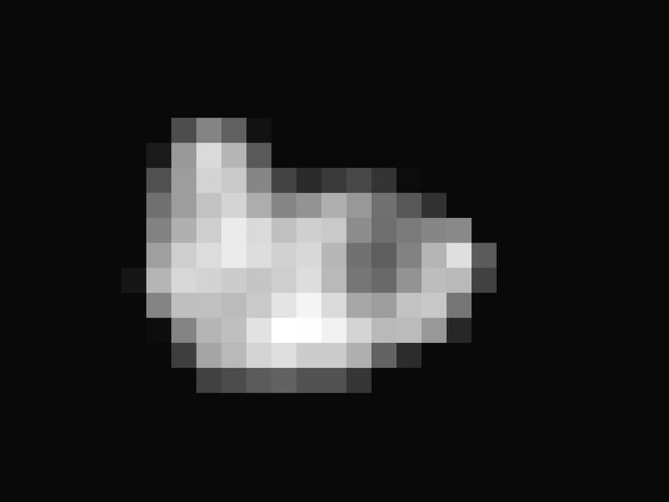 Der Pluto-Mond Hydra als pixeliger, weisser Fleck vor schwarzem Hintergrund.