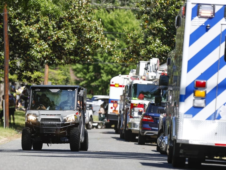 ATV vor einer Reihe von Krankenwagen und Feuerwehrfahrzeugen auf einer Strasse