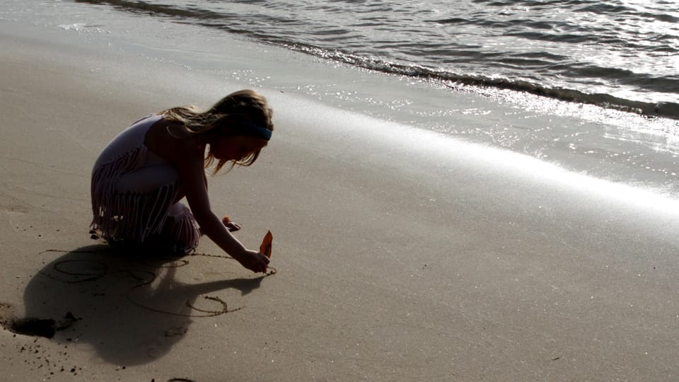 Ein Mädchen spielt am Strand (Symbolbild).
