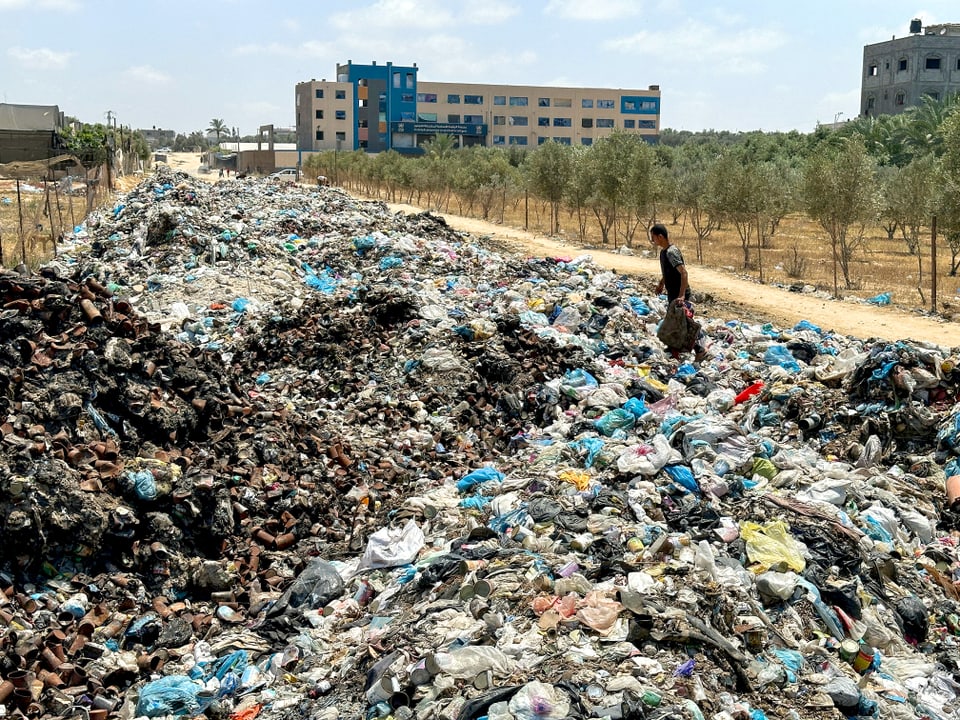 Endlose Hügel aus Abfall säumen eine Strasse in Deir Al-Balah.