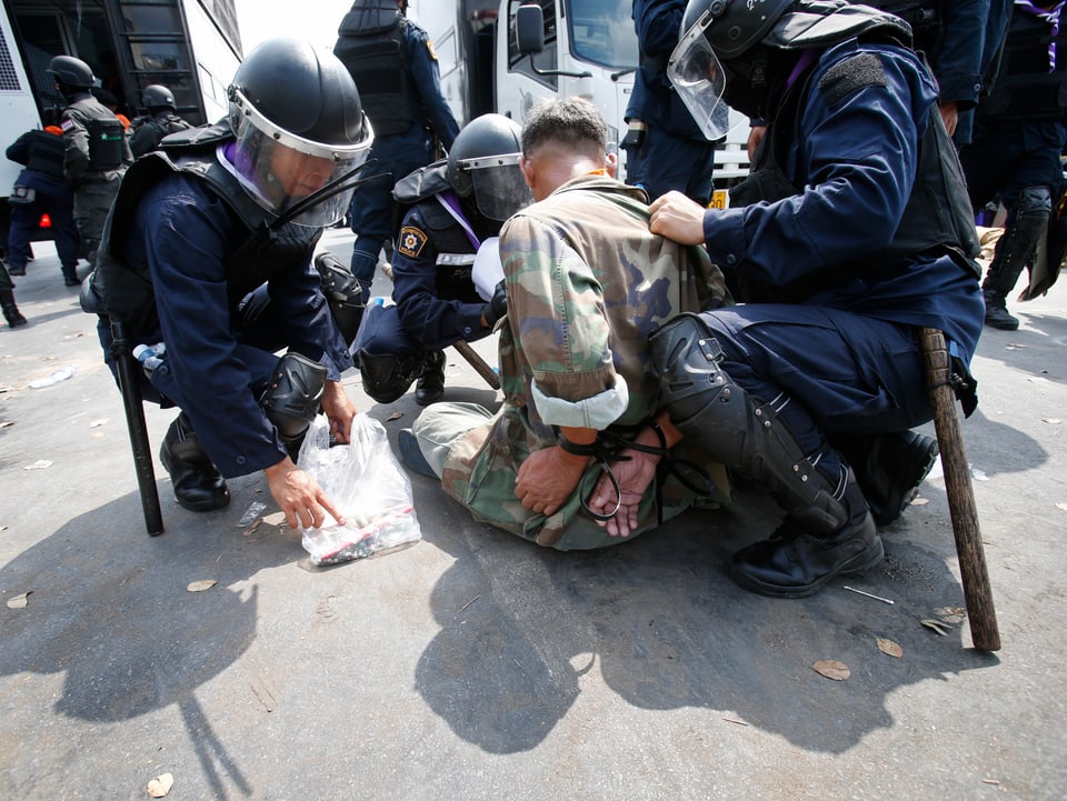 Polizisten nehmen einen Demonstranten fest