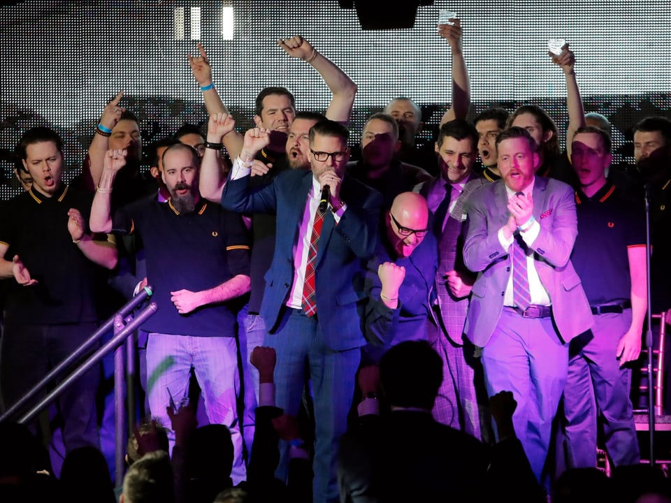 Gavin McInnes steht auf der Bühne, umgeben von jungen, weissen Männern.