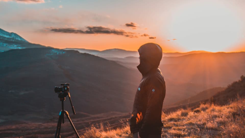 Sonnenaufgang mit Kamera und Mann um Vordergrund