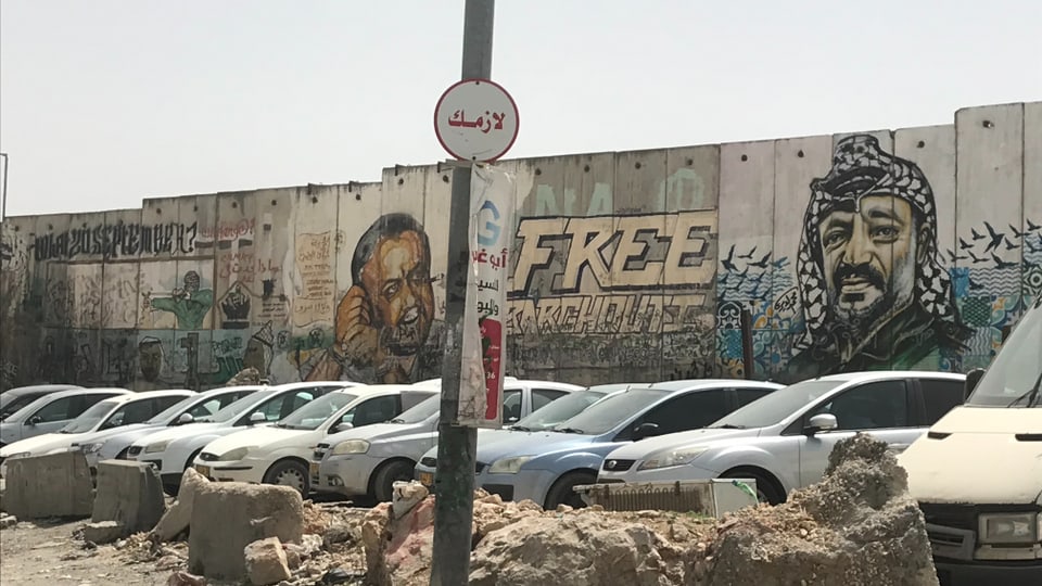 Grossflächige Porträts von Jassir Arafat sowie Marwan Barghouthi an einer Mauer.