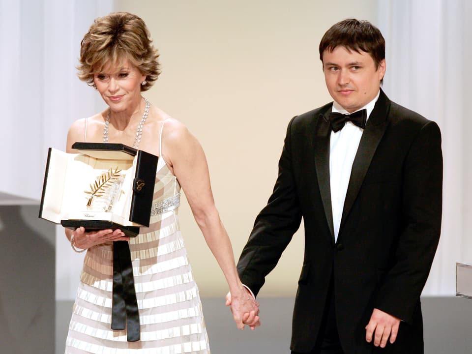 Regisseur neben ihm einen Schauspielerin, die die Goldene Palme trägt.