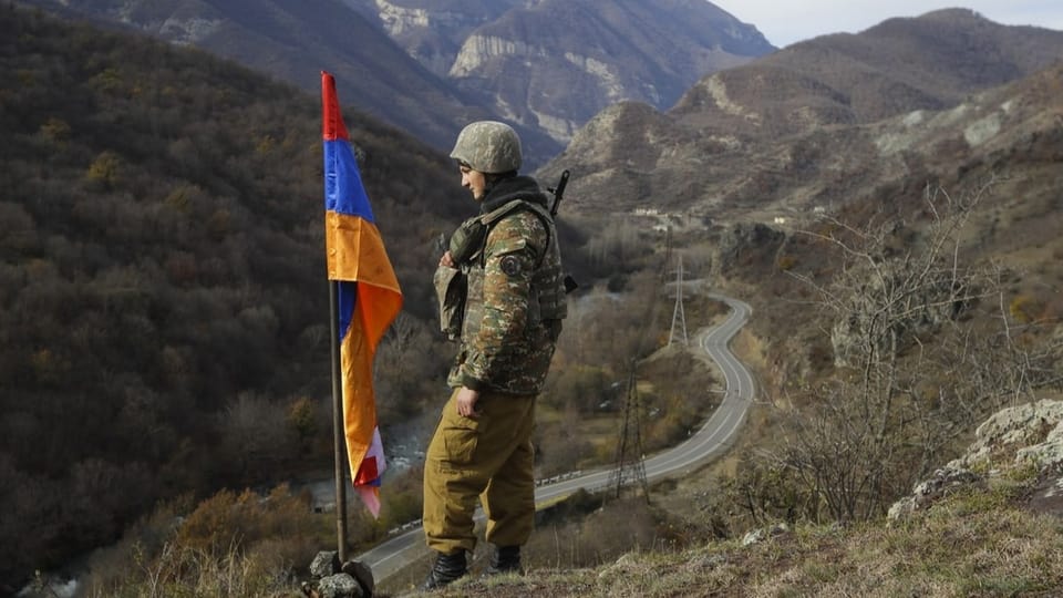 Armenischer Soldat neben der Flagge von Berg-Karabach.