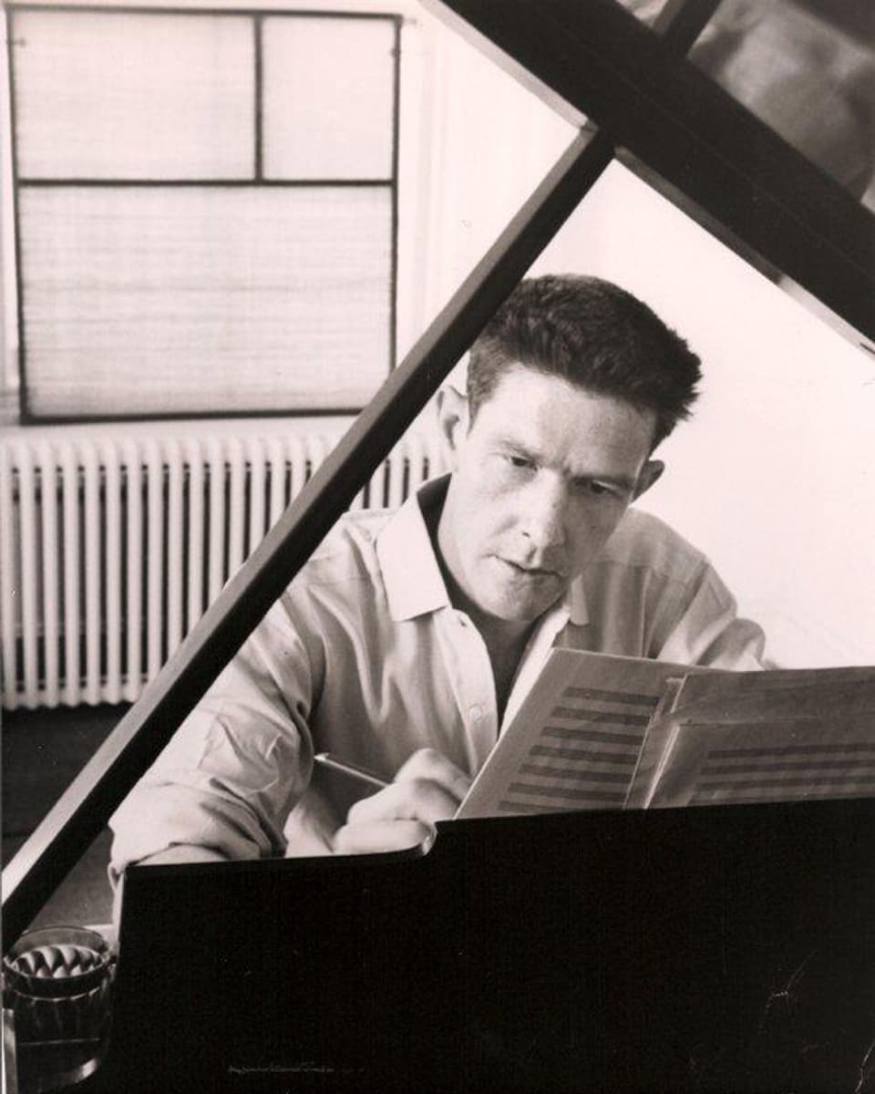 John Cage in jungen Jahren, an einer Komposition arbeitend an seinem Klavier.