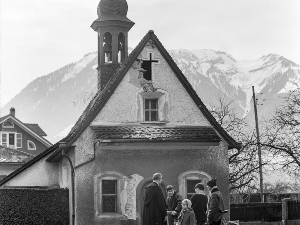 Ein Geistlicher mit Kindern vor der beschädigten St.-Antonia-Kapelle in Sarnen.