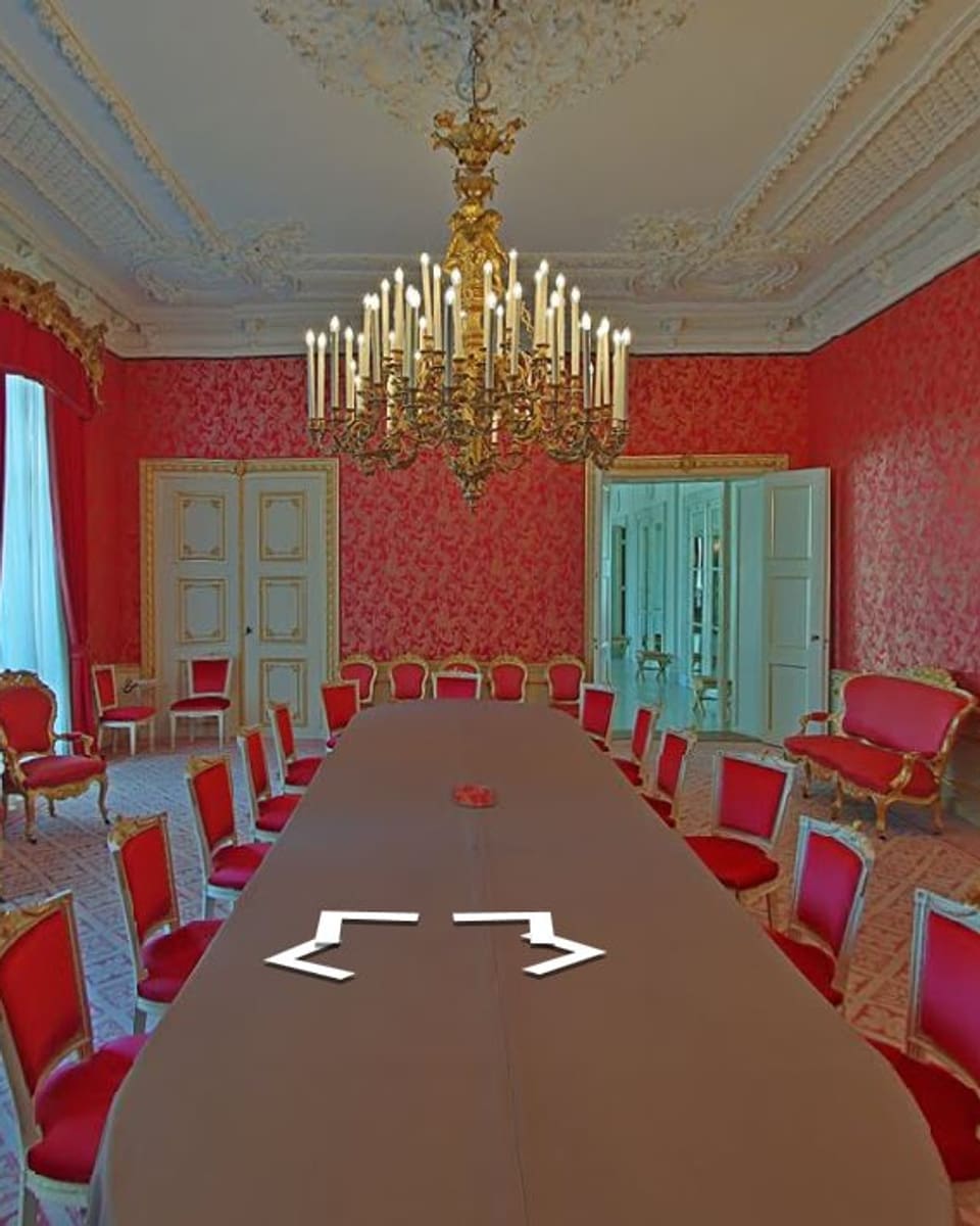 Grosses ovaler Tisch in rotem Prunksaal.