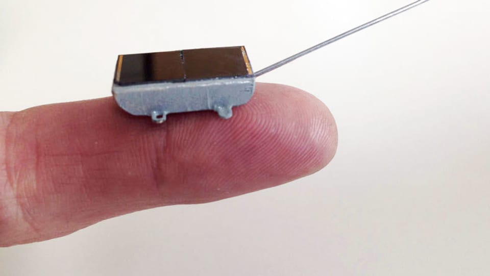Ein extrem kleiner Sensor hält ein Mensch auf seinem Finger